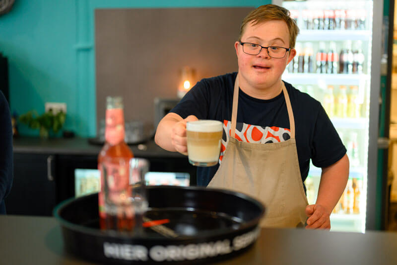 Café Homborner Werkstatt, Servicekraft serviert einen Cappuciono